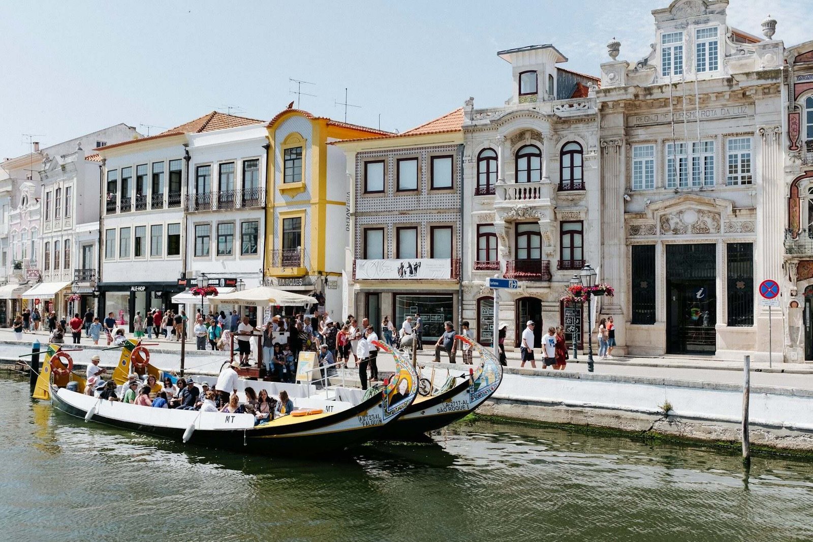 Barco moliceiro no canal central de Aveiro em frente a edifícios arte nova