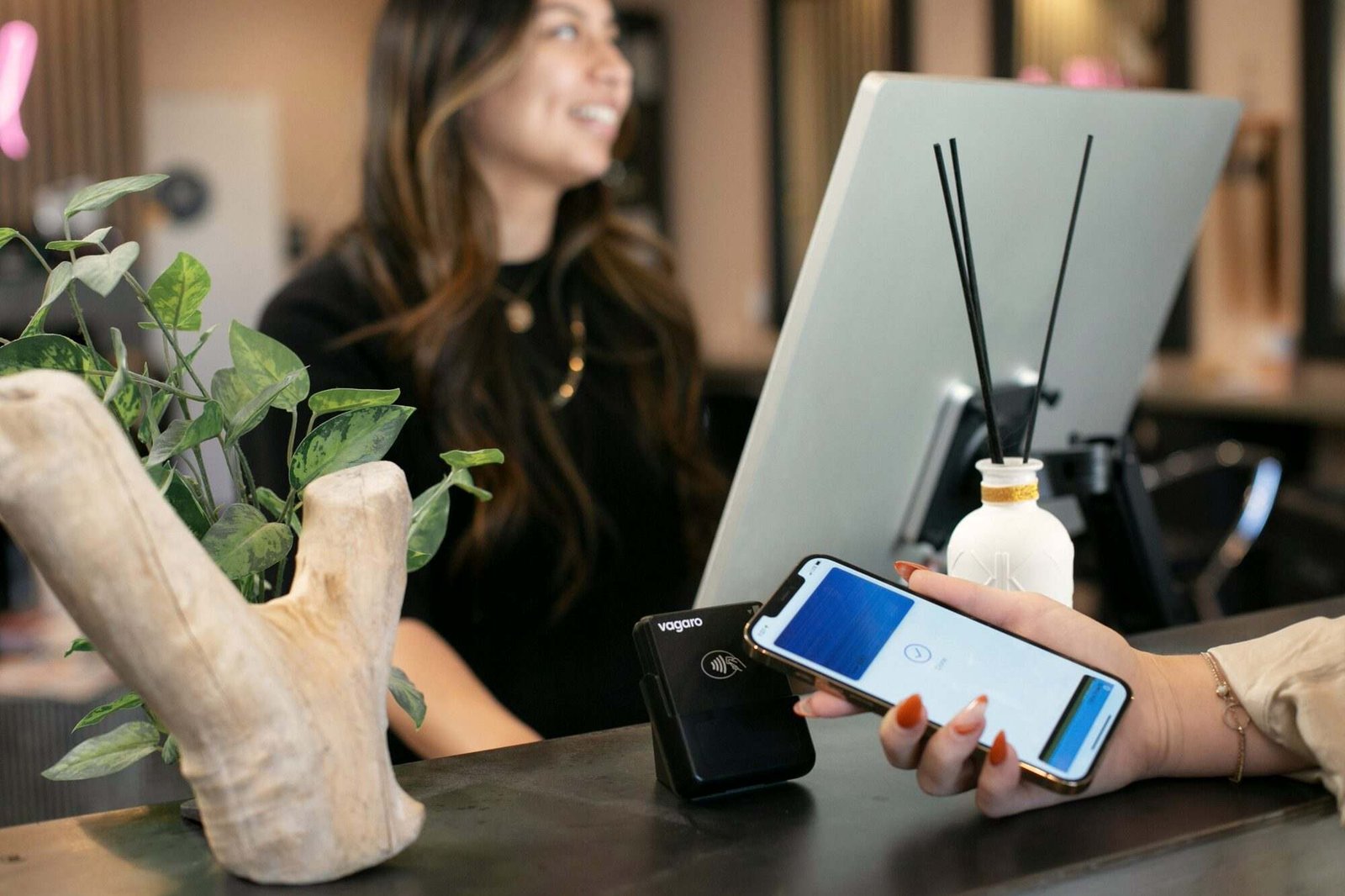 Cliente a pagar com o telemóvel no balcão de uma loja