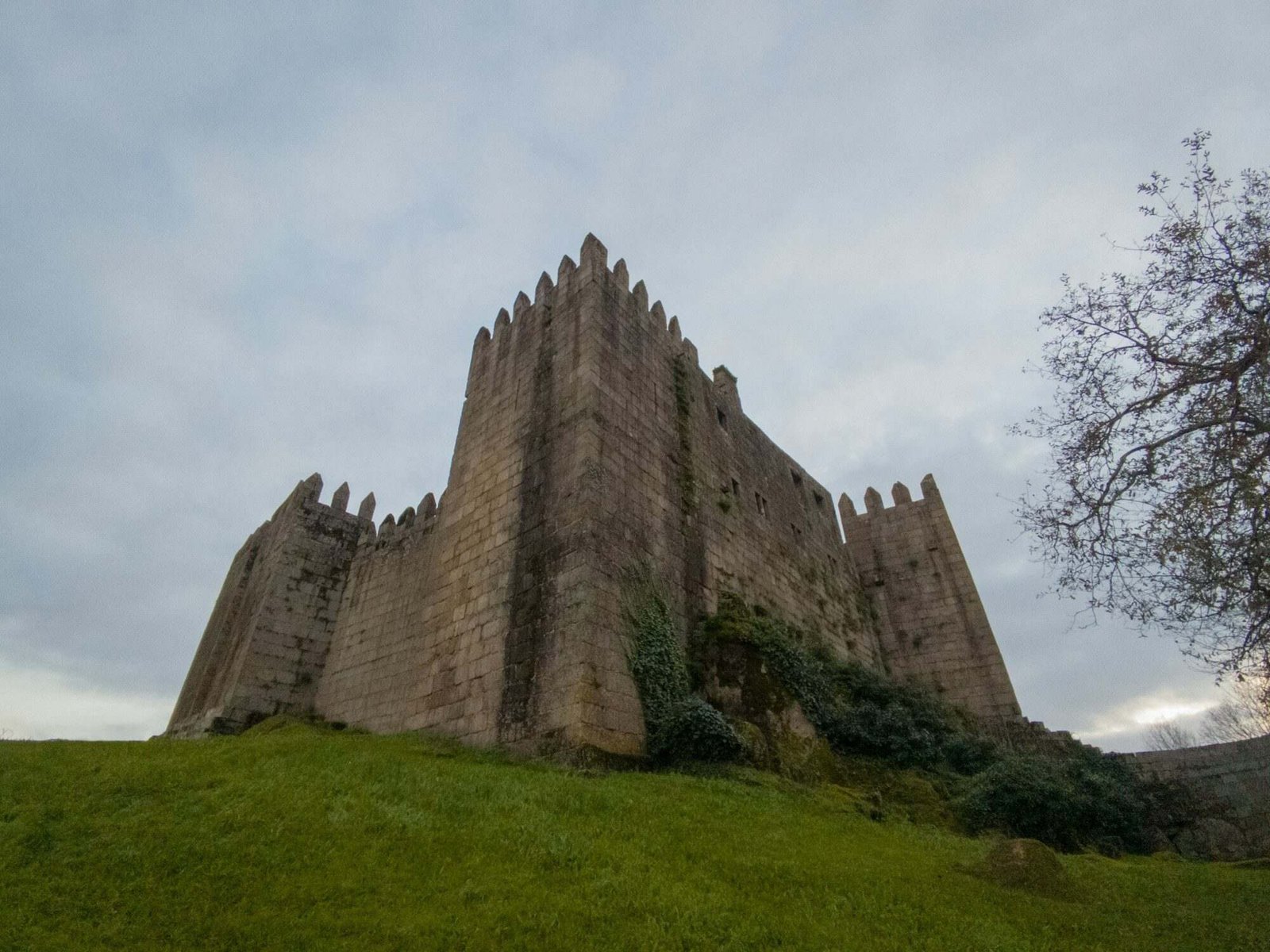 Castelo de Guimarães no alto da colina com céu nublado