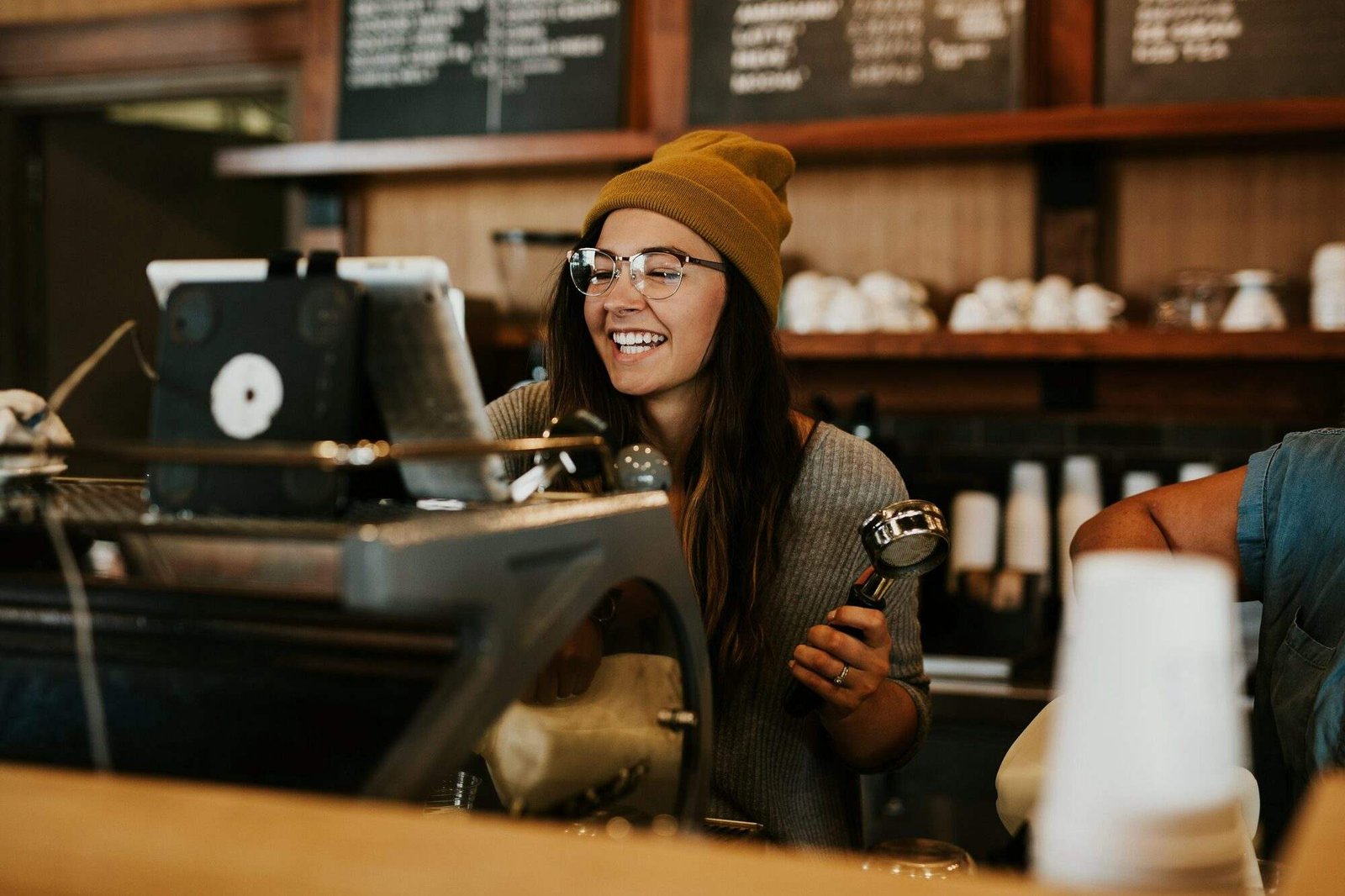 Barista sonriente detrás de la barra de una cafetería