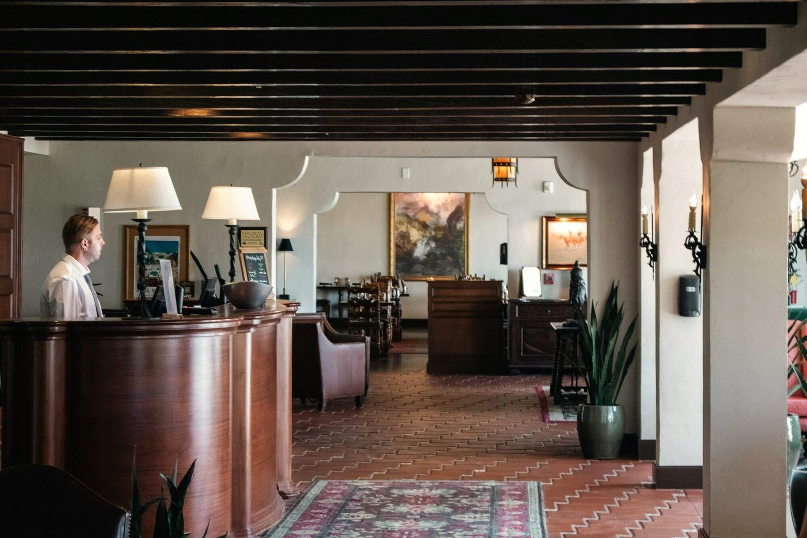 Recepcionista en el mostrador de un pequeño hotel con salón