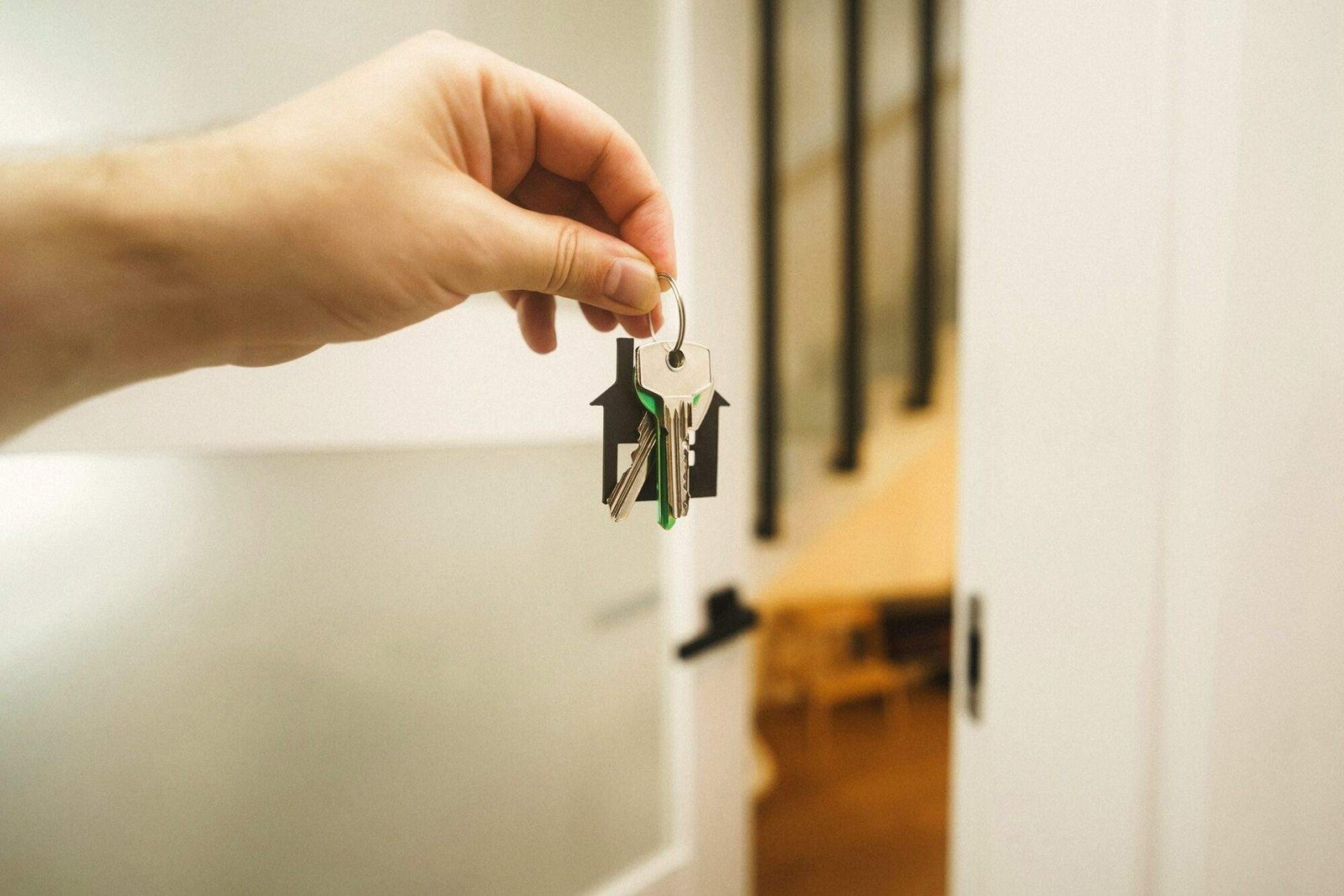 Mano entregando las llaves de una vivienda en la puerta